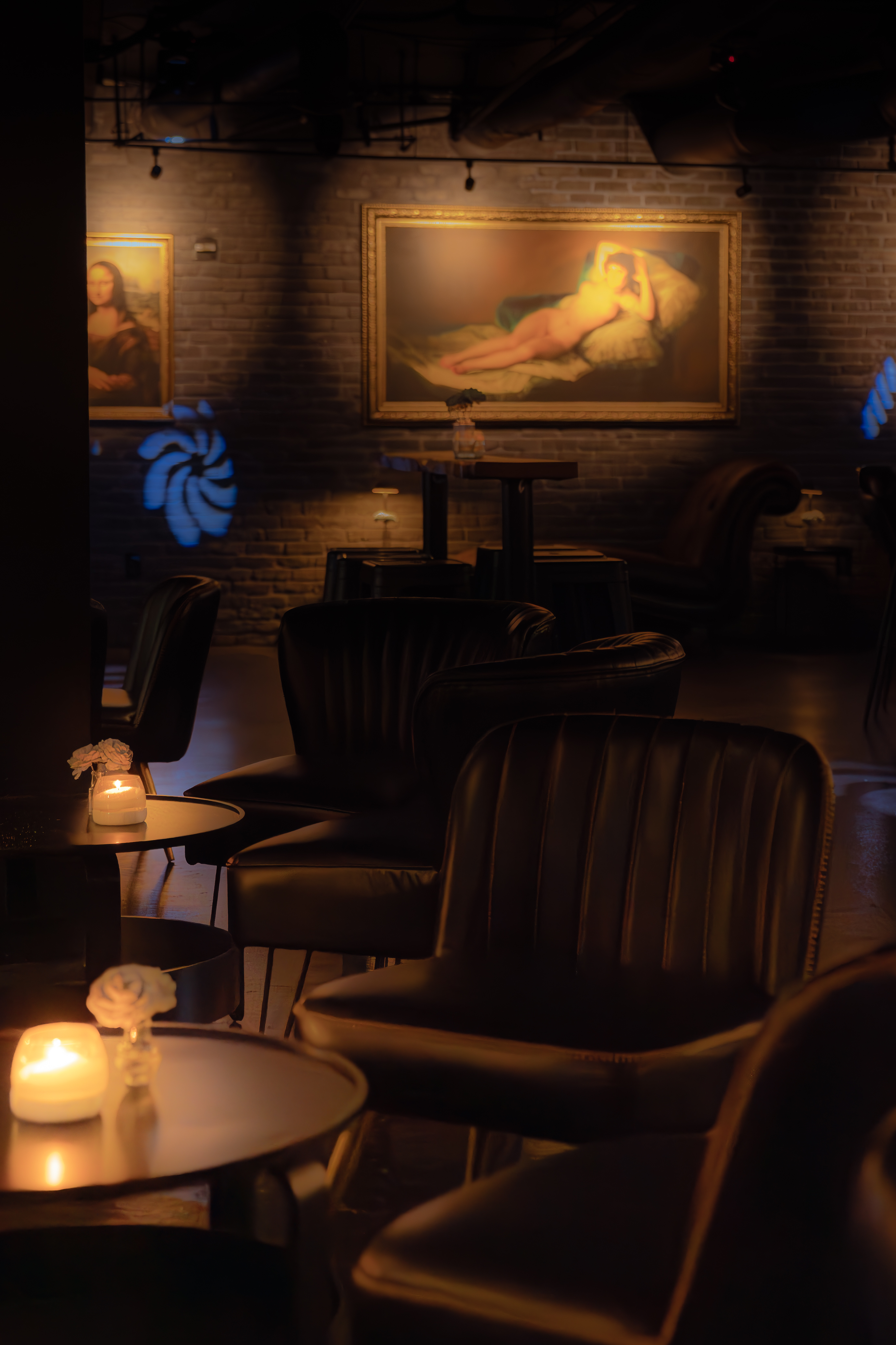 Dim leather lounge seating and framed paintings at The Bunker
