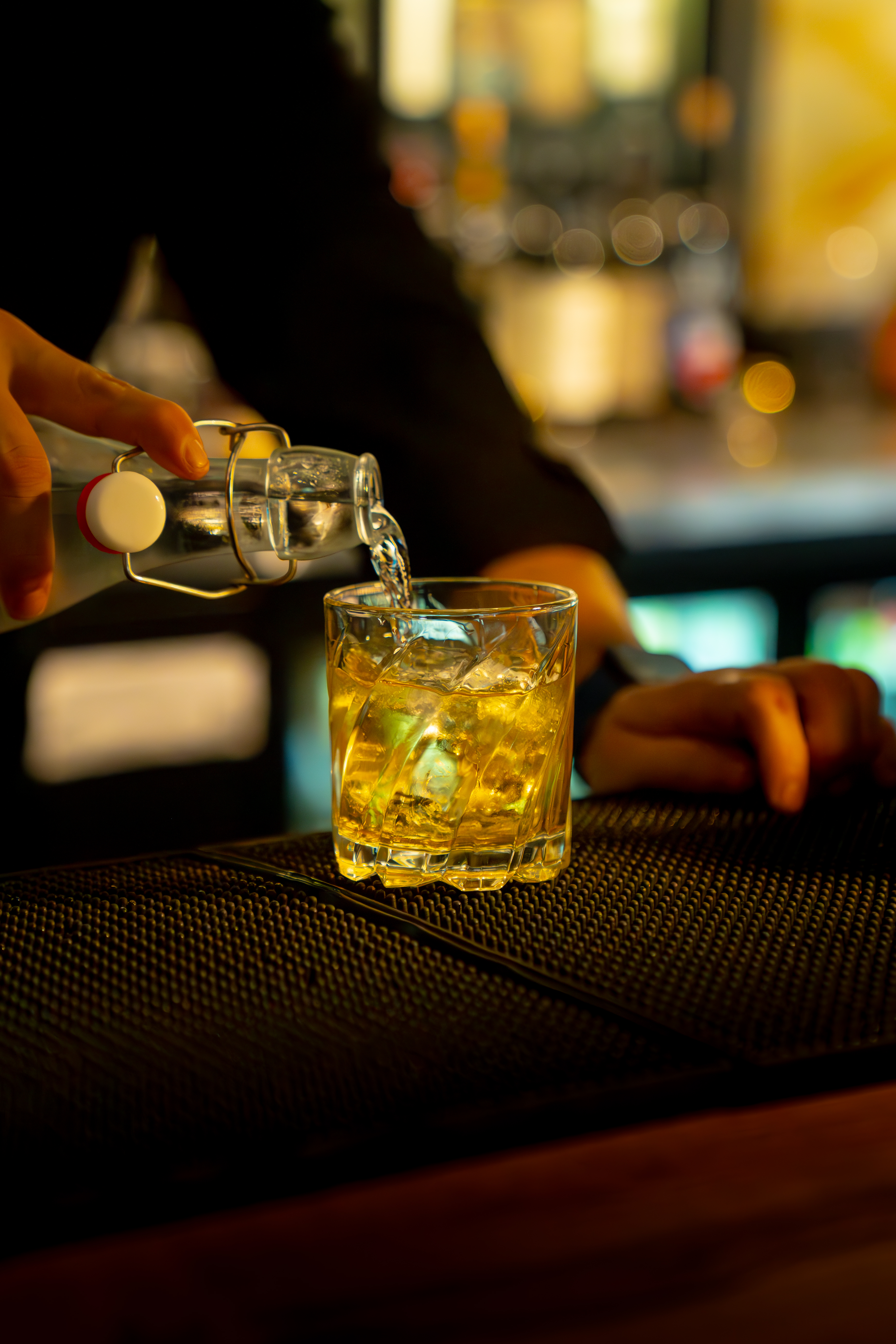 Spirit being poured over ice into a rocks glass at The Bunker