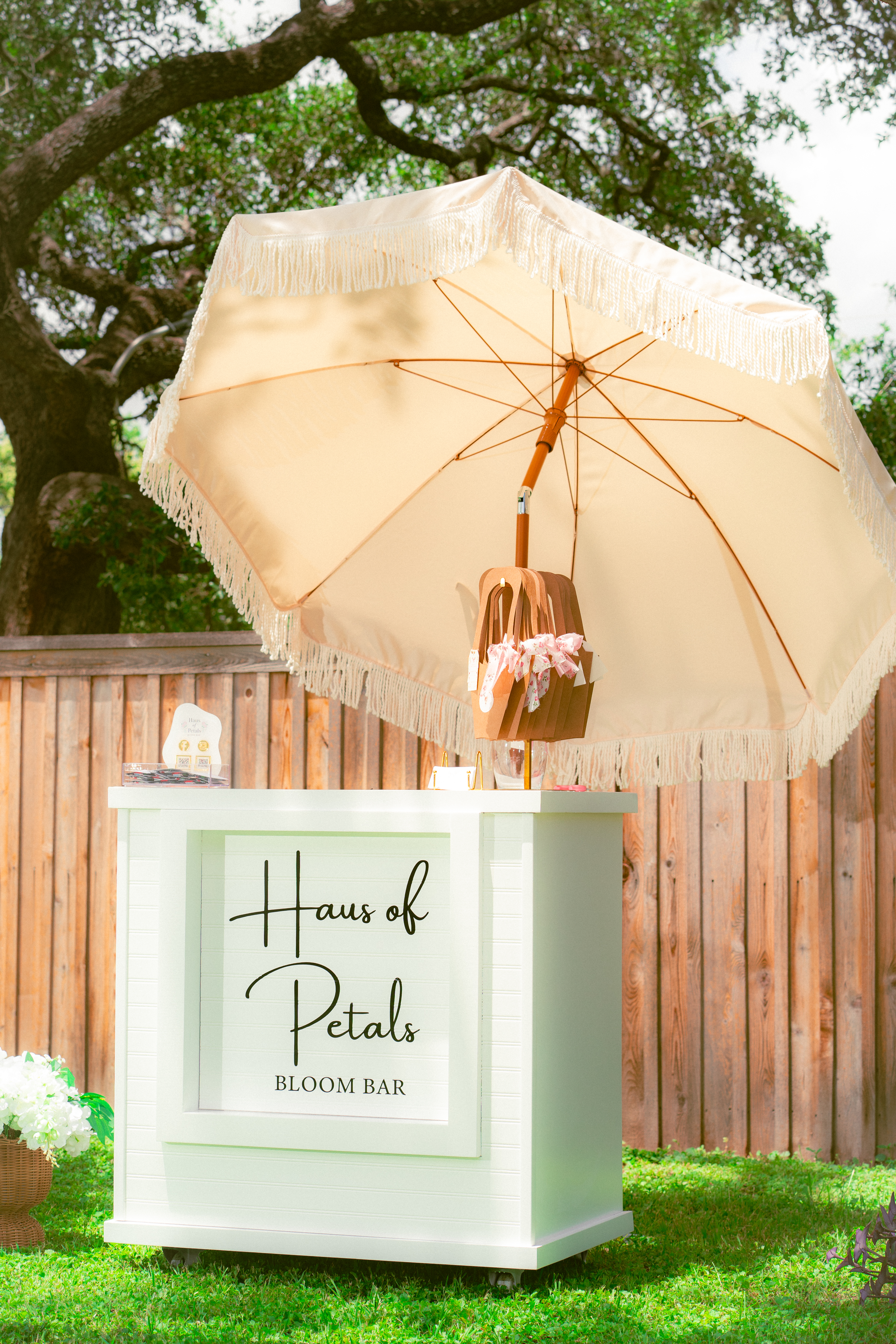 Haus of Petals bloom bar cart under a cream fringed umbrella, Austin TX