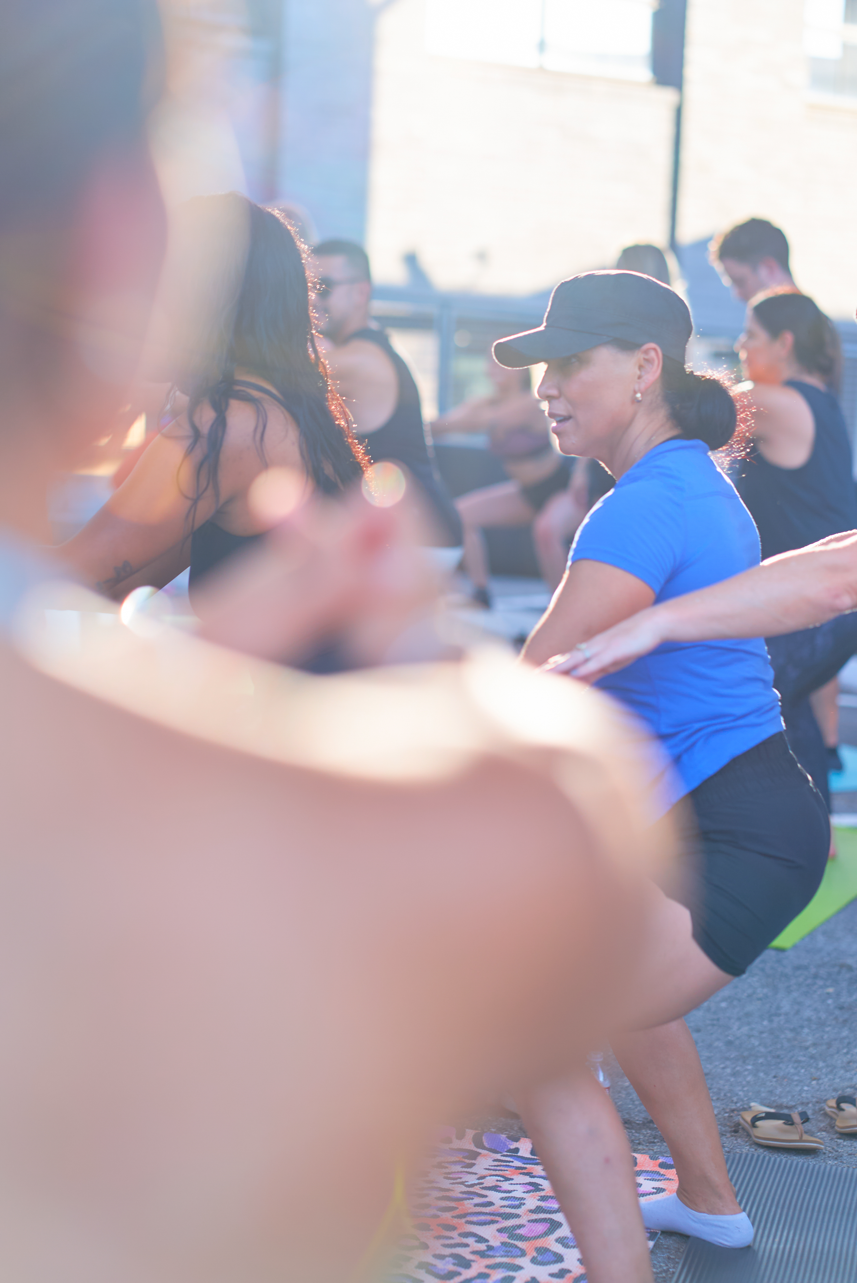 Instructor coaching an outdoor pilates class in golden light at the Native Roots event